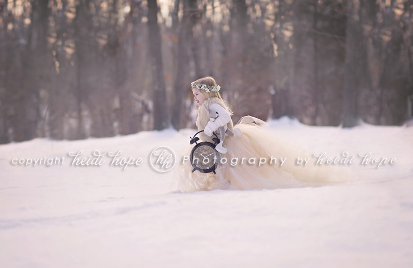 Girl in tutu running in snow with large clock