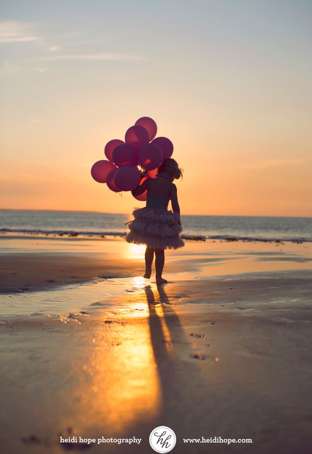birthday girl holding balloons at the beach at sunrise by #heidihopephotography